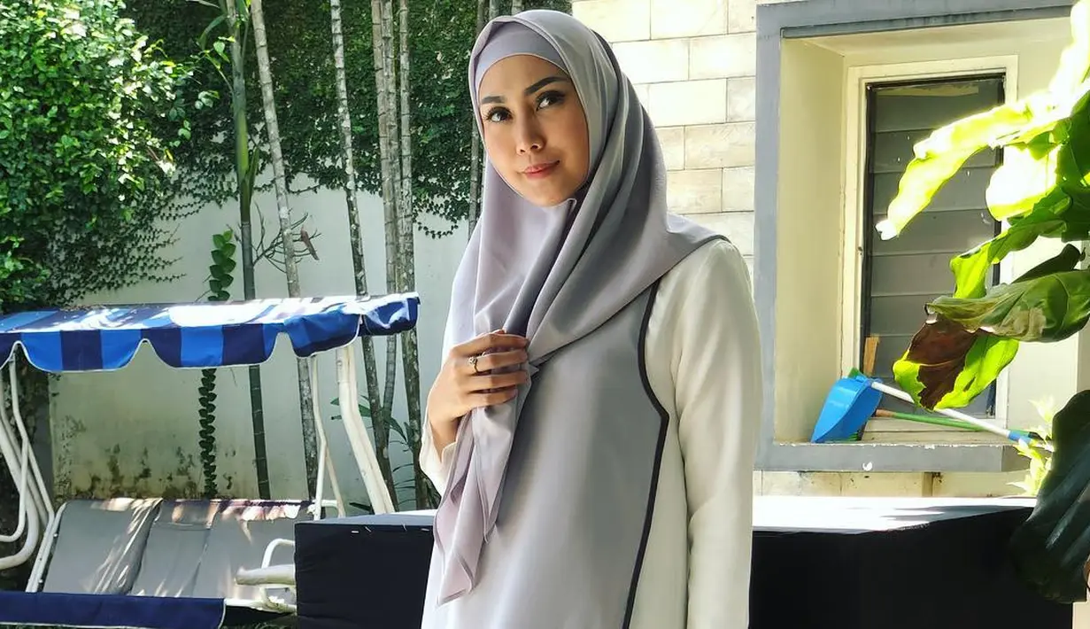 Selanjutnya, Fenita terlihat santun dan bikin hati adem. Ia mengenakan gamis berwarna putih yang terdapat aksen abu-abunya. Untuk hijabnya sendiri, Fenita memilih warna abu-abu dan dibuat menutupi bagian dadanya. (Instagram/fenitarie)