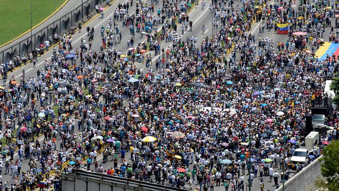 Ribuan orang berkumupul saat menggelar aksi menentang Presiden Nicolas Maduro di Caracas, Venezuela (24/4). Pihak oposisi menyalahkan Nicolas Maduro atas krisis ekonomi di negara tersebut.(AFP/Federico Parra)