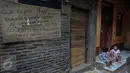 Tulisan protes terhadap penggusuran ditulis di tembok rumah warga di kawasan pemukiman Kampung Pulo, Jakarta Timur, Kamis (23/7). Pemerintah Provinsi DKI Jakarta akan menertibkan bangunan liar yang ada di wilayah Kampung Pulo. (Liputan6.com/Faizal Fanani)