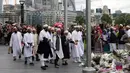 Sejumlah muslim datang membawa karangan bunga di Potters Field Park, London, Senin (5/6). Mereka mengenang dan mendoakan korban serangan teror di London Bridge dan Borough Market yang menewaskan 7 orang dan melukai puluhan lainnya. (AP Photo/Tim Ireland)