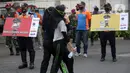 Pejalan kaki melintas saat sosialisasi penerapan protokol kesehatan PSBB di Bundaran HI, Jakarta, Minggu (13/9/2020). Kepastian pemberlakuan kembali PSBB di Jakarta masih dibahas antara Pemprov DKI dan pemerintah pusat dan akan diumumkan nanti sore. (merdeka.com/Arie Basuki)
