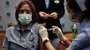 Seorang petugas kesehatan disuntik vaksin COVID-19 CoronaVac dari Sinovac, di Institut Penyakit Menular Bamrasnaradura di Bangkok, Minggu (28/2/2021). Pemerintah Thailand berencana memvaksinasi 50 persen dari total populasinya hingga akhir tahun ini. (Lillian SUWANRUMPHA/AFP)