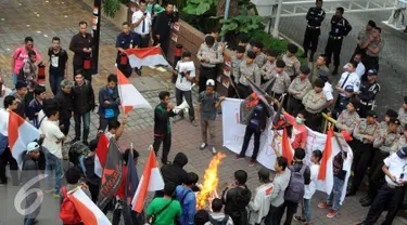 Petugas polisi berjaga di depan kantor Freeport, Kuningan , Jakarta, Jumat (18/12). Dalam aksinya mereka menuntut pemerintah untuk segera melakukan nasionalisasi terhadap PT Freeport. (Liputan6.com/Helmi Afandi)