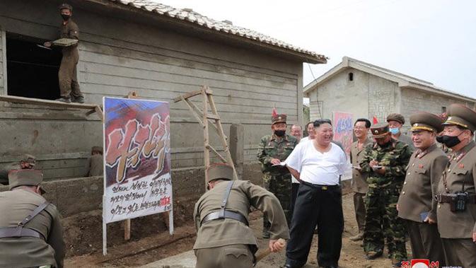 Kim Jong-un tampak santai saat blusukan mengecek dampak banjir di Provinsi Hwanghae Utara. Dok: media pemerintah Korut via KCNA Watch