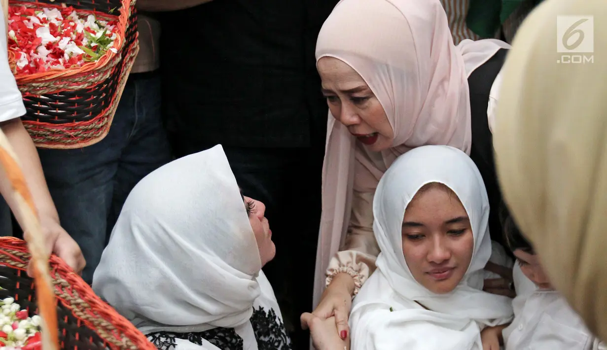 Penyanyi Dewi Yul saat bersalaman dengan istri almarhum RMH Heroe Siswanto atau dikenal Sys NS usai pemakaman di TPU Jeruk Purut, Jakarta, Selasa (23/1). (Liputan6.com/Herman Zakharia)