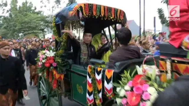 Pada kirab resepsi Kahiyang-Bobby dari atas kereta kencana Presiden Jokowi membagikan suvenir pernikahan kepada warga.