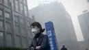 Warga mengenakan masker saat kabut asap menyelimuti Beijing, China, Senin (30/11). Pemerintah setempat mengumumkan keadaan siaga dan menyarankan warga Beijing untuk berada dalam rumah karena kandungan polusi udara yang berbahaya. (AFP PHOTO/ Wang Zhao)