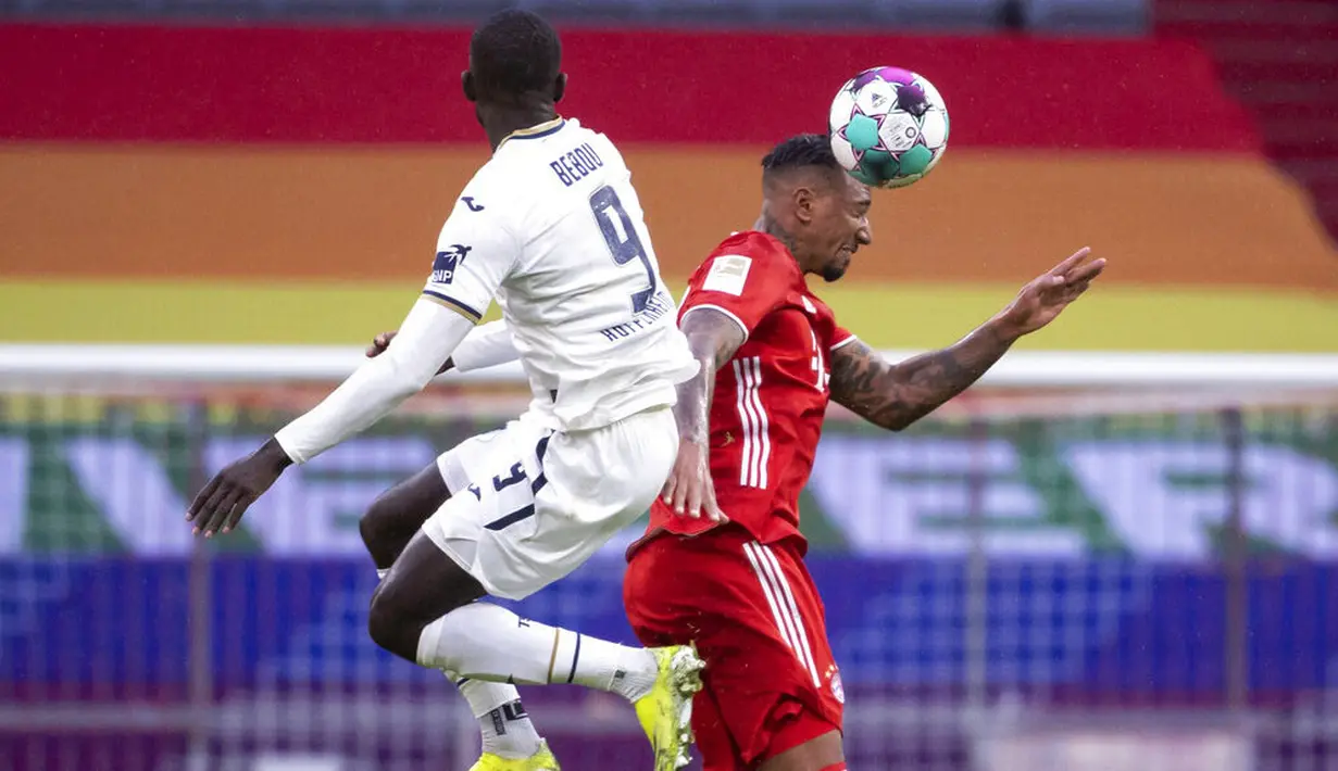 Bek Bayern Munchen, Jerome Boateng, duel udara dengan pemain Hoffenheim, Ihlas Bebou, pada laga Bundesliga di Stadion Allianz Arena, Sabtu (30/1/2021). Bayern Munchen menang dengan skor 4-1. (Sven Hoppe/dpa via AP)