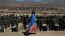 Seorang fotografer wanita pribumi suku Aymara melintas di depan barisan pasukan militer saat peringatan ulang tahun tentara Bolivia ke-192 di Kjasina, Bolivia (7/8). (AP Photo/Juan Karita)