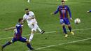 Penyerang Real Madrid, Karim Benzema melakukan tendangan dibayangi pemain Eibar pada laga lanjutan Liga Spanyol di Stadion Ipurua, Senin dinihari WIB (21/12/2020). Benzema menjadi pahlawan dalam kemenangan Madrid karena menciptakan satu gol dan dua assist di laga tersebut. (AP/Alvaro Barrientos)