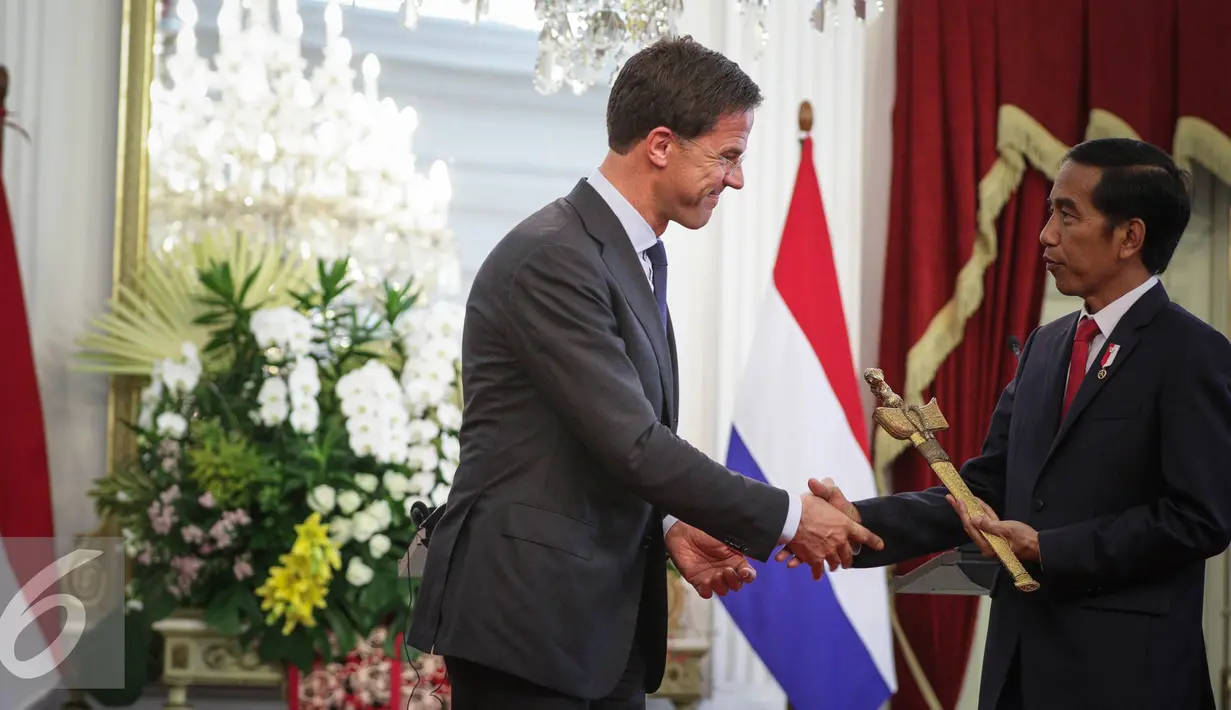 Perdana Menteri Kerajaan Belanda Mark Rutte (kiri) memberikan cindramata sebuah keris kepada Presiden Joko Widodo seusai memberikan pernyataan bersama di Istana Merdeka, Jakarta, Rabu (23/11). (Liputan6.com/Faizal Fanani)