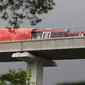 Petugas mengecek kereta ringan lintas rel terpadu (LRT) Jabodebek yang mengalami kecelakaan di jalur lintas LRT Cibubur, Jakarta Timur, Senin (25/10/2021). Petugas terlihat ada di rel untuk membantu proses evakuasi di mana bagian gerbong kereta ditutup terpal. (Liputan6.com/Herman Zakharia)