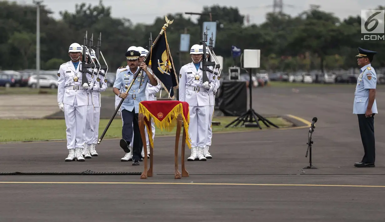 Panglima TNI Marsekal Hadi Tjahjanto membawa panji-panji TNI AU Swa Bhuwana Paksa saat memimpin upacara serah terima jabatan KSAU di Lapangan Udara Halim Perdanakusuma, Jakarta, Jumat (19/1). (Liputan6.com/Faizal Fanani)