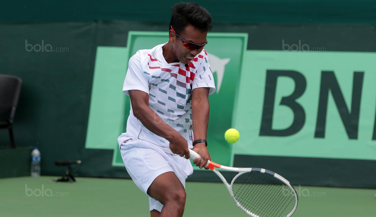 Althaf Dhaifullah mengembalikan bola saat melawan petenis Filipina, Alberto “AJ” Lim Jr. pada Piala Davis 2018 grup dua Asia/Oceania di Senayan, Jakarta, Sabtu (3/2/2018). (Bola.com/Nick Hanoatubun)