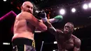 Wilder gantian bikin Fury kelabakan dan terjatuh di ronde empat. Bukan cuma sekali, tapi dalam dua kesempatan. Hanya saja, daya tahan tubuh Fury lebih baik dan mampu bangkit lagi. (AFP via Getty Images/Al Bello)