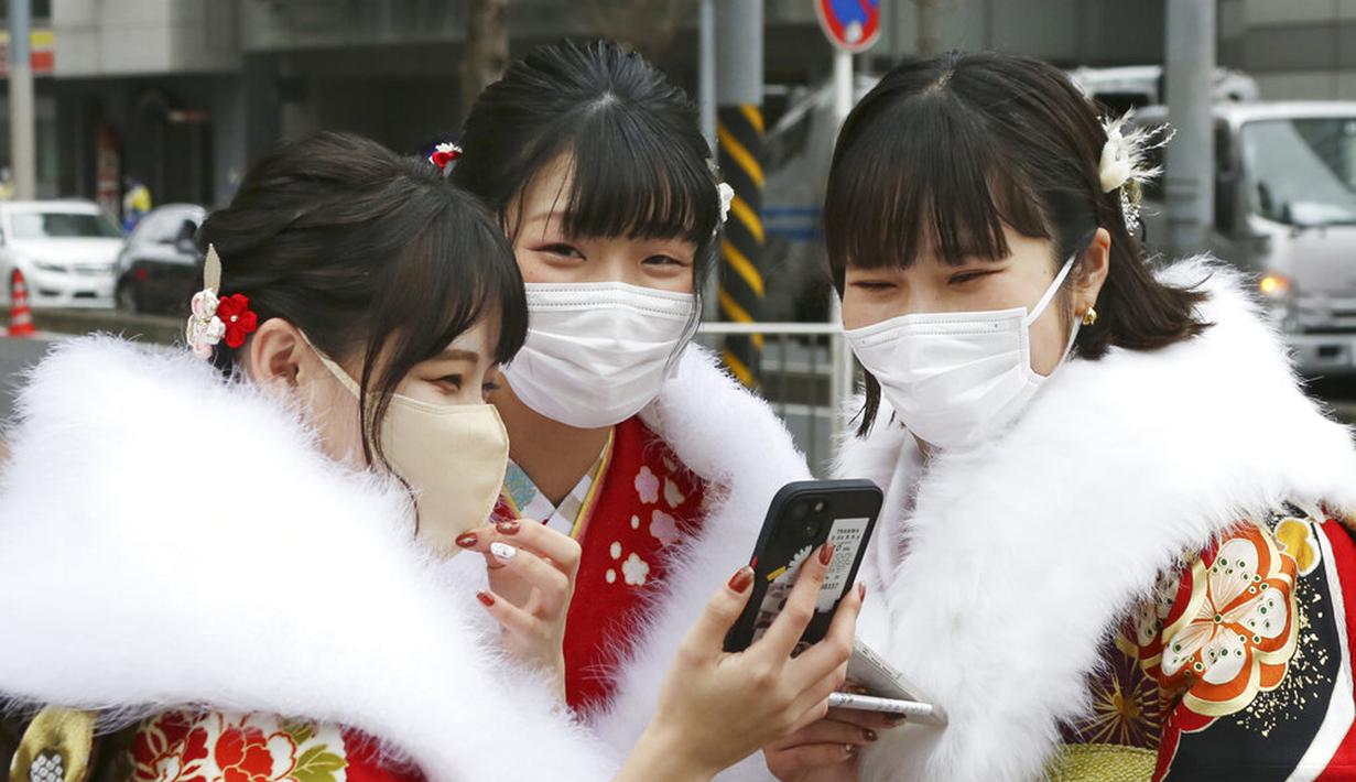 Para wanita berbaju kimono yang baru menginjak usia 20 tahun berfoto untuk merayakan Coming of Age Day di Yokohama, Jepang, Senin (10/1/2022). Coming of Age Day diadakan setiap tahun pada Senin kedua bulan Januari untuk merayakan remaja Jepang menjadi dewasa. (AP Photo/Koji Sasahara)