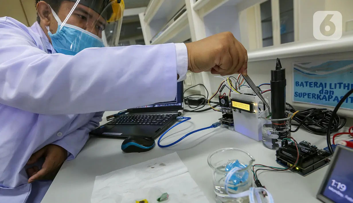 Peneliti melakukan proses uji PH pada kain berlapis tembaga di Pusat Penelitian Fisika LIPI Puspitek, Serpong, Tangerang Selatan, Senin (8/6/2020). Tim peneliti berhasil mengembangkan masker kain disinfektor yang mampu membunuh virus Covid-19 dan bisa dicuci ulang. (Liputan6.com/Fery Pradolo)