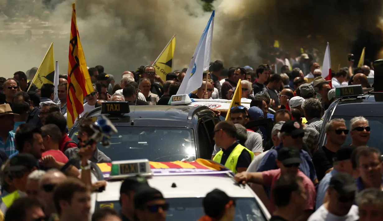 Sejumlah orang yang tergabung dalam Serikat Pekerja Taksi Spanyol menggelar demonstrasi di Madrid, Spanyol, Selasa (30/5). Sopir taksi Spanyol  memprotes layanan mobil berbasis online karena harganya terlalu murah. (AP Photo / Francisco Seco)