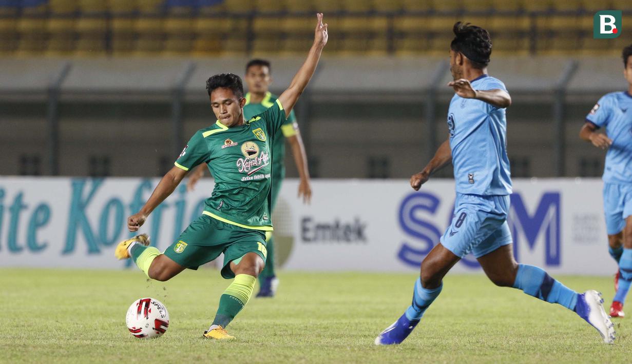 Gelandang Persebaya Surabaya, Muhammad Kemaluddin (kiri) menendang bola di depan gelandang Persela Lamongan, Syahroni dalam laga Grup C Piala Menpora 2021 di Stadion Si Jalak Harupat, Bandung, Sabtu (3/4/2021). (Bola.com/Ikhwan Yanuar)
