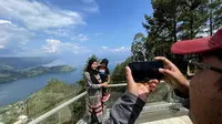 Pengunjung berfoto dengan latar belakang Danau Toba di Taman Simalem Resort, Karo, Sumatera Utara (Sumut) (Reza Efendi/Liputan6.com)