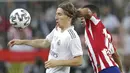 Gelandang Real Madrid, Luka Modric, berebut bola dengan pemain Atletico Madrid, Renan Lodi, pada laga Piala Super Spanyol di King Abdulla Sports City, Jeddah, Senin (13/1/2020). Real Madrid menang adu penalti 4-1 atas Atletico Madrid. (AP/Hassan Ammar)