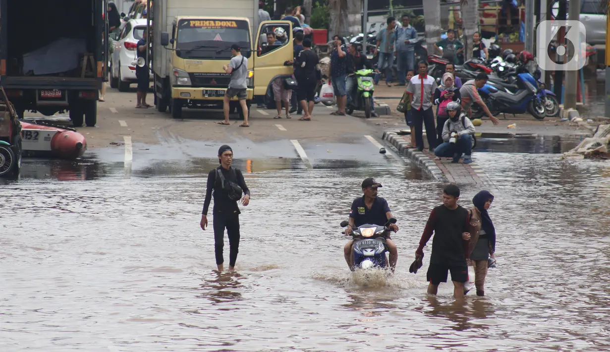 Pengendara dan pejalan kaki melewati perempatan Green Garden, Kedoya, Jakarta, Jumat (3/1/2020). Hingga hari ke-3, banjir masih menggenangi sekitar kawasan perempatan Green Garden, Kedoya akibatnya pengendara harus lebih waspada menghindari mesin kemasukan air. (Liputan6.com/Helmi Fithriansyah)