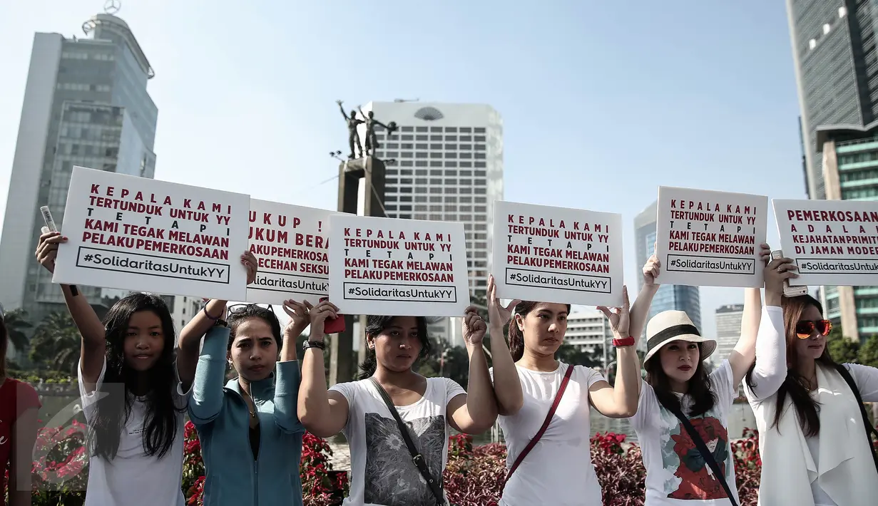 Sejumlah peserta memegang poster disela kegiatan car free day di Bundaran HI, Jakarta, Minggu (8/5). Aksi itu merupakan solidaritas serta bentuk kecaman terhadap kekerasan seksual yang menimpa pelajar asal Bengkulu Yuyun (14). (Liputan6.com/Faizal Fanani)