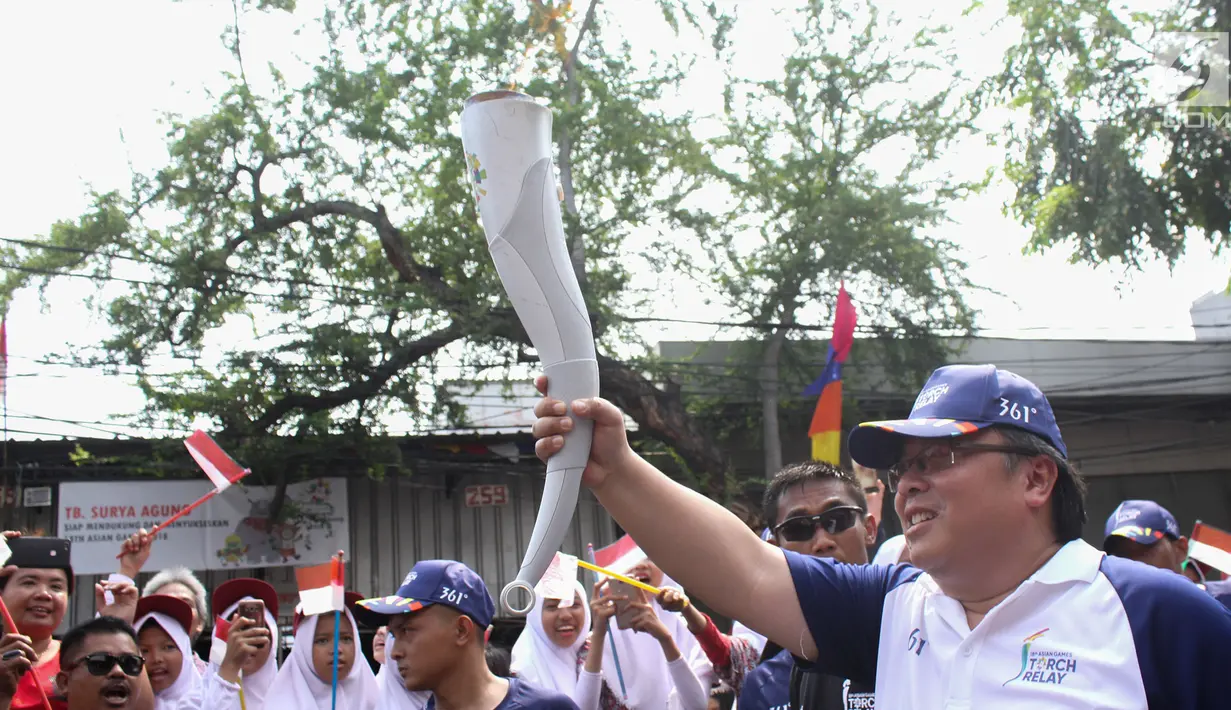 Menteri PPN/Kepala Bappenas Bambang Brodjonegoro  membawa Obor Asian Games 2018 untuk di arak berkeliling Jakarta Barat.(Liputan6.com/  Herman Zakharia)