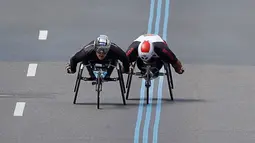 Atlet asal Swiss, Marcel Hug (kiri) dan atlet asal Afrika Selatan, Ernst Van Dyk bersaing dalam kejuaraan balap kursi roda kategori pria pada ajang Boston Marathon ke-121 di Boston, Senin (17/4). (AP Photo/Charles Krupa)