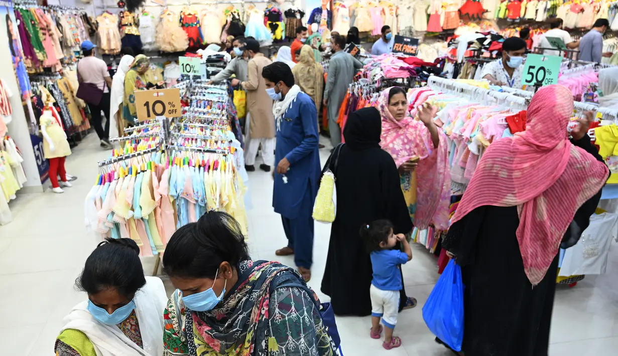 Orang-orang memadati toko saat berbelanja menjelang perayaan Idul Fitri yang akan datang di tengah pandemi corona Covid-19, di Rawalpindi, Pakistan pada 5 Mei 2021. Pusat perbelanjaan ramai oleh warga Pakistan yang berbelanja aneka kebutuhan untuk menyambut Lebaran. (Farooq NAEEM / AFP)