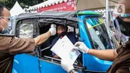 Petugas mengukur suhu pengemudi bajaj saat tes diagnostik cepat (rapid test) di depan gedung Kejaksaan Agung, Jakarta, Kamis (6/8/2020). Kejagung menggelar rapid test massal kepada warga yang melintas di kawasan itu guna mengantisipasi penyebaran COVID-19. (Liputan6.com/Faizal Fanani)