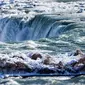 Es dan air mengalir di tepi Horseshoe Falls dari Air Terjun Niagara di Ontario, Kamis (31/1). Saat AS dilanda suhu yang lebih dingin dari Antartika, temperatur di Kanada juga menurun menjadi minus 18 derajat Celcius (Tara Walton/The Canadian Press via AP)