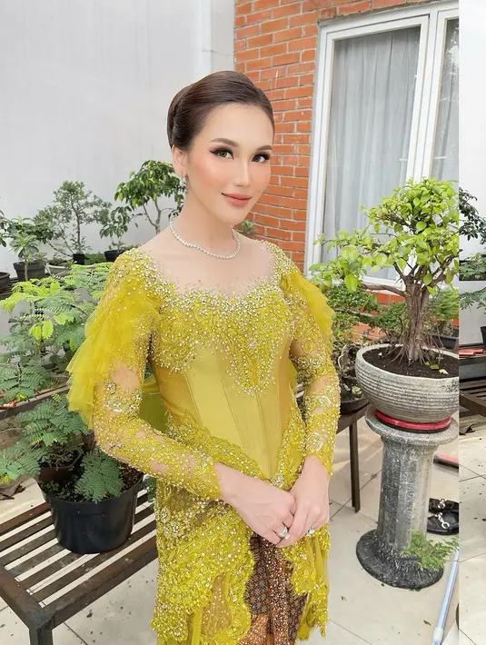 Di acara pernikahan sepupunya, ibu Bilqis itu tampil cantik mengenakan kebaya warna hijau lemon yang segar. Kebaya modern ini hadir dengan detail lengan ruffle dan detail payet di bagian dada hingga lengan. Ia memadukan kebayanya dengan kain jarik batik warna cokelat tua. [@ayutingting92]