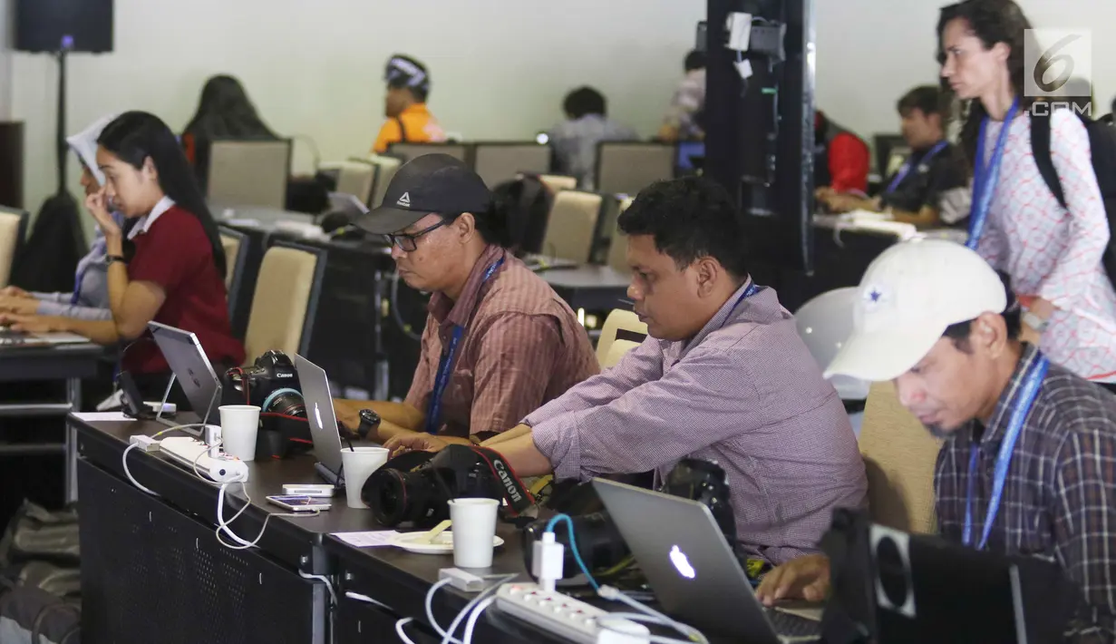 Jurnalis berbagai negara mengetik berita pertemuan tahunan IMF-Bank Dunia di Nusa Dua, Bali, Senin (8/10). Menkominfo Rudiantara memastikan fasilitas internet kencang untuk tamu dan media dalam pertemuan tahunan ini. Liputan6.com/Angga Yuniar)