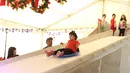 Seorang anak berseluncur di perosotan es di Lippo Mal Puri, Jakarta, Jumat (22/12). Jelang Natal banyak pusat perbelanjaan mendekor bangunannya bernuansa natal untuk menarik daya tarik minat masyarakat. (Liputan6.com/Angga yuniar)