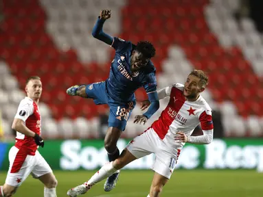 Gelandang Arsenal, Thomas Partey ditantang oleh penyerang Slavia Praha, Jan kuchta pada leg kedua perempat final Liga Europa di Stadion Sinobo, Praha, Jumat (16/4) dini hari WIB.  Arsenal lolos ke semifinal Liga Europa setelah menang telak 4-0 di markas Slavia Praha. (AP Photo/Petr David Josek)