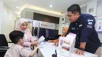 Pelaksana Tugas Regional CEO Jakarta West Bank Muamalat Erick Ermawan (kanan) menyaksikan proses pembukaan rekening tabungan haji anak oleh salah satu nasabah di kantor cabang Bank Muamalat Melawai, Jakarta Selatan. (Dok Bank&nbsp;Muamalat)