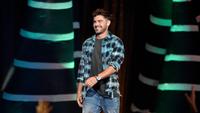 Aktor Zac Efron naik ke atas panggung untuk menerima penghargaan pada acara Teen Choice Awards di California, 12 Agustus 2018.  Mengenakan kemeja serta celana denim, Zac Efron kembali memancarkan pesona ketampanannya. (Chris Pizzello/Invision/AP)