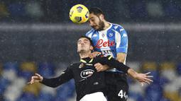 Pemain Napoli, Nikola Maksimovic, duel udara dengan pemain Spezia, Giulio Maggiore, pada laga Liga Italia di Stadion Diego Armando Maradona, Rabu (6/1/2021). Napoli takluk dengan skor 1-2. (Alessandro Garofalo/LaPresse via AP)