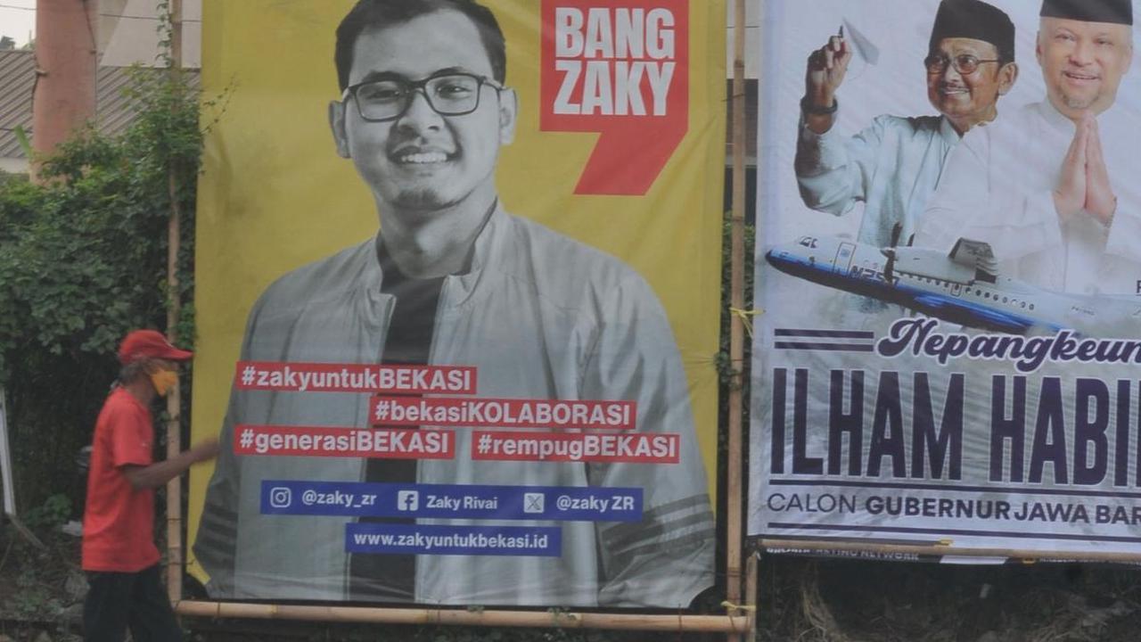 Seorang warga berjalan melewati alat peraga kampanye pilkada&nbsp;yang terpasang di Jalan Raya Bekasi, Bekasi, Jawa Barat, Kamis (11/7/2024).&nbsp;Merdeka.com/Imam Buhori