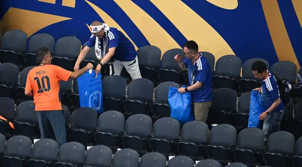Aksi terpuji suporter Jepang yang selalu membersihkan sampah di tribun seusai pertandingan telah menjadi tradisi ikonik yang mendunia. (AP Photo/Jessica Tobias)
