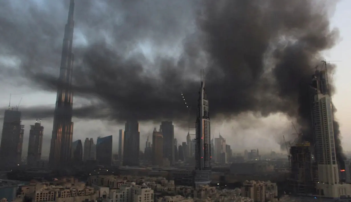 Asap mengepul di lokasi konstruksi sebelah Dubai Mall, Uni Emirat Arab, Minggu (2/4). Kebakaran terjadi sekitar pukul 06.30 pagi waktu setempat. (AP Photo/ Anthea Ayache)