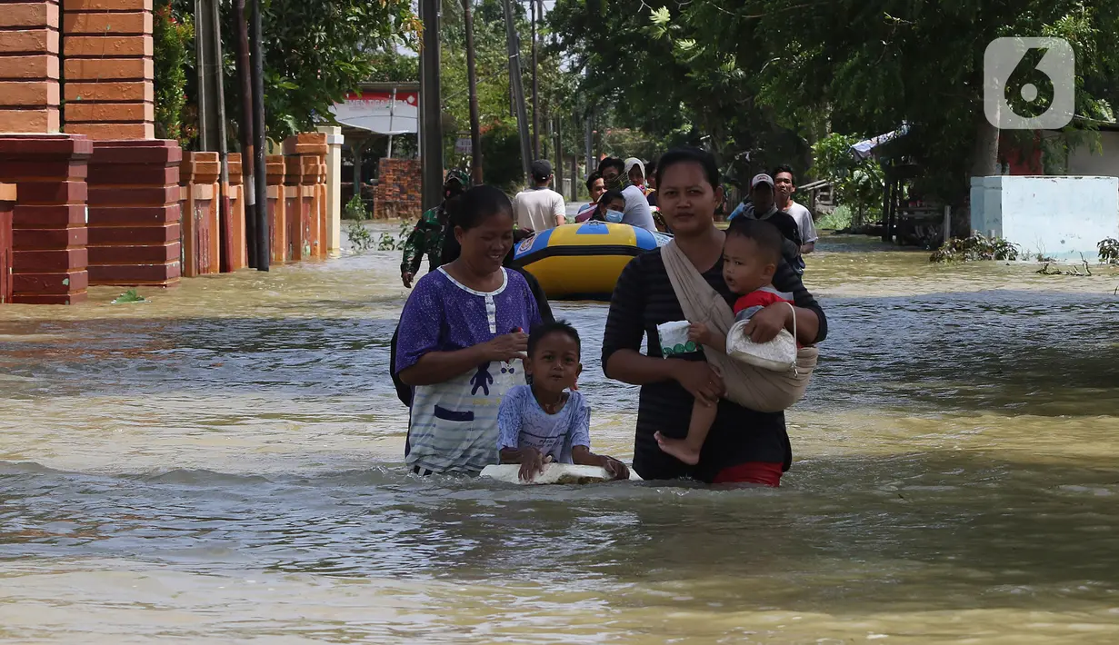 Warga melintasi banjir di Desa Sukalaksana Kabupaten Bekasi, Jawa Barat, Senin (22/02/2021). Ketinggian air di sekitar permukiman warga mencapai 1,5 meter. (Liputan6.com/Herman Zakharia)