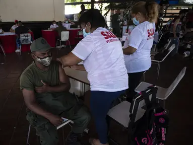 Reaksi tentara Venezuela ketika menerima dosis pertama kandidat vaksin Covid-19 Abdala buatan Kuba selama kampanye vaksinasi massal di Fuerte Tiuna, Caracas, Rabu (30/6/2021). Venezuela pada 24 Juni 2021 menandatangani kontrak untuk membeli 12 juta dosis vaksin Abdala. (Yuri CORTEZ/AFP)