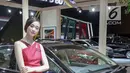 Sales Promotion Girl (SPG) berpose di samping kendaraan yang dipamerkan dalam ajang Indonesia International Motor Show (IIMS) 2019 di JIExpo Kemayoran, Jakarta, Kamis (25/4). (Liputan6.com/Faizal Fanani)