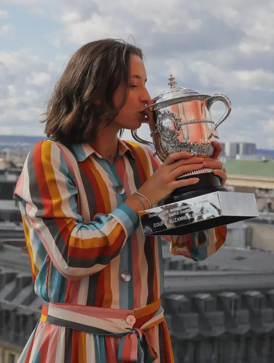 Petenis Polandia Iga Swiatek berpose dengan trofi juara Prancis Terbuka 2020 saat sesi foto di rooftop Galeries Lafayette, Paris, Prancis, Minggu (11/10/2020). Petenis berusia 19 tahun ini mencatatkan diri sebagai sosok Polandia pertama yang memenangkan Grand Slam. (AP Photo/Christophe Ena)