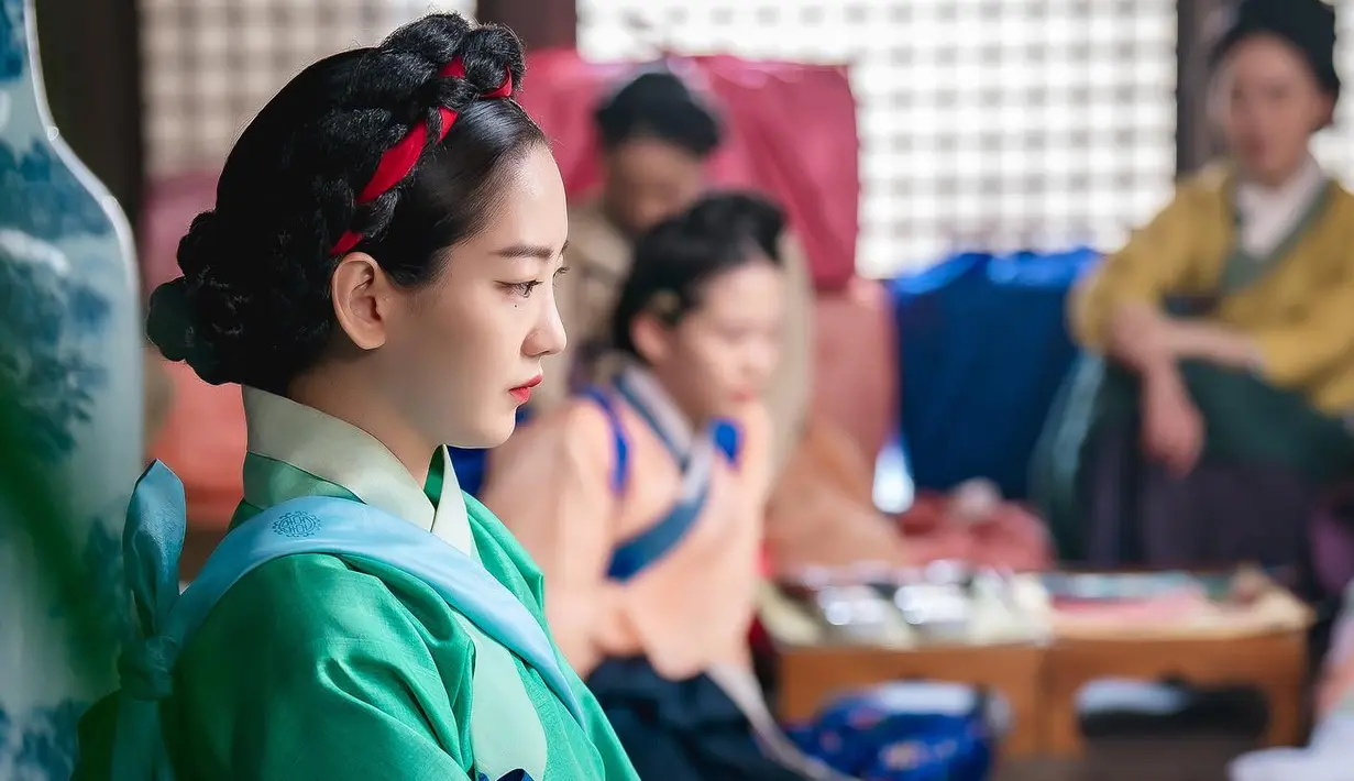 <p>Soon Deok memancarkan karisma dengan riasan mata yang berani dan gache (wig tradisional Korea yang dikenakan oleh wanita) yang dihiasi pita merah.</p>