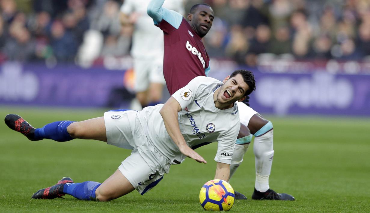 Striker Chelsea, Alvaro Morata, terjatuh saat berebut bola dengan gelandang West Ham United, Pedro Obiang, pada laga Premier League di Stadion London, Sabtu (10/12/2017). Chelsea Takluk 0-1 dari West Ham United. (AP/Alastair Grant)