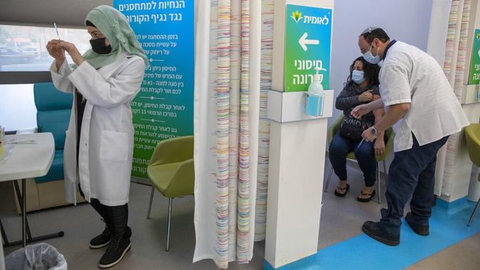Staf medis menyiapkan vaksin virus corona COVID-19 Pfizer di Pusat Vaksinasi COVID-19, Yerusalem, Jumat (8/1/2021). Israel memperketat lockdown nasional dengan membatasi pertemuan publik selama dua minggu mulai Jumat. (AP Photo/Ariel Schalit)