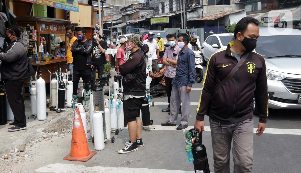 Antrean warga bersama tabung oksigen medis di sekitar kios pengisian ulang Medical Oxygen di Jalan Minangkabau Timur, Jakarta, Senin (5/7/2021). Permintaan kebutuhan oksigen medis kian meningkat seiring naiknya kasus orang terkonfirmasi positif COVID-19. (Liputan6.com/Helmi Fithriansyah)